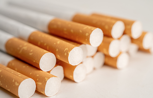 Close-up of several cigarettes on a white surface.