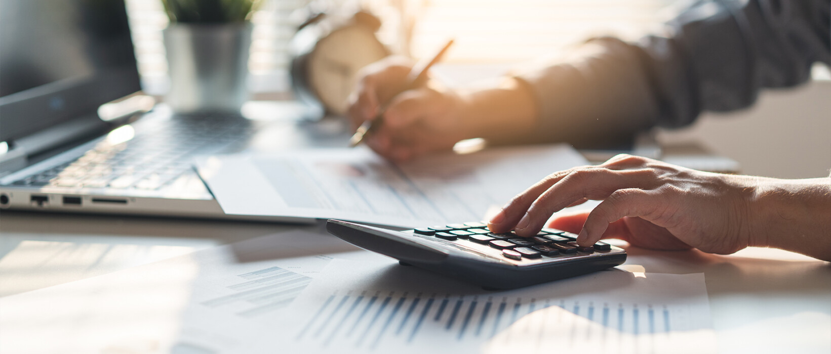 Person using a calculator to review advertising costs and data.