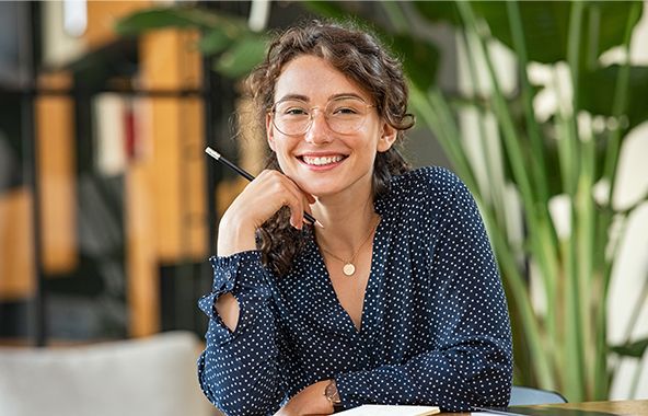 Smiling intern sitting at a desk with a notebook.