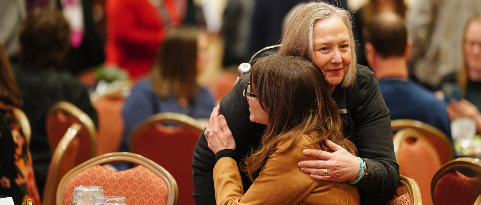 Two people embracing at an Iowa newspaper event.