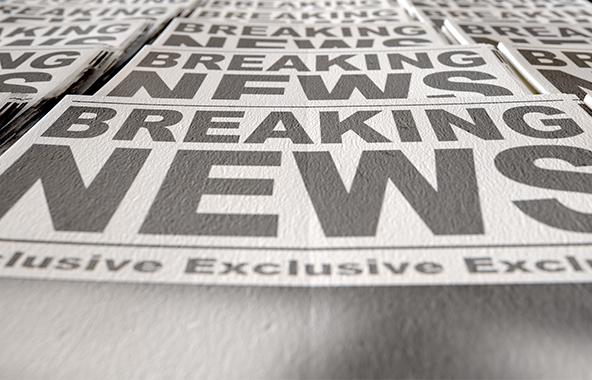 Newspapers with large breaking news headlines.