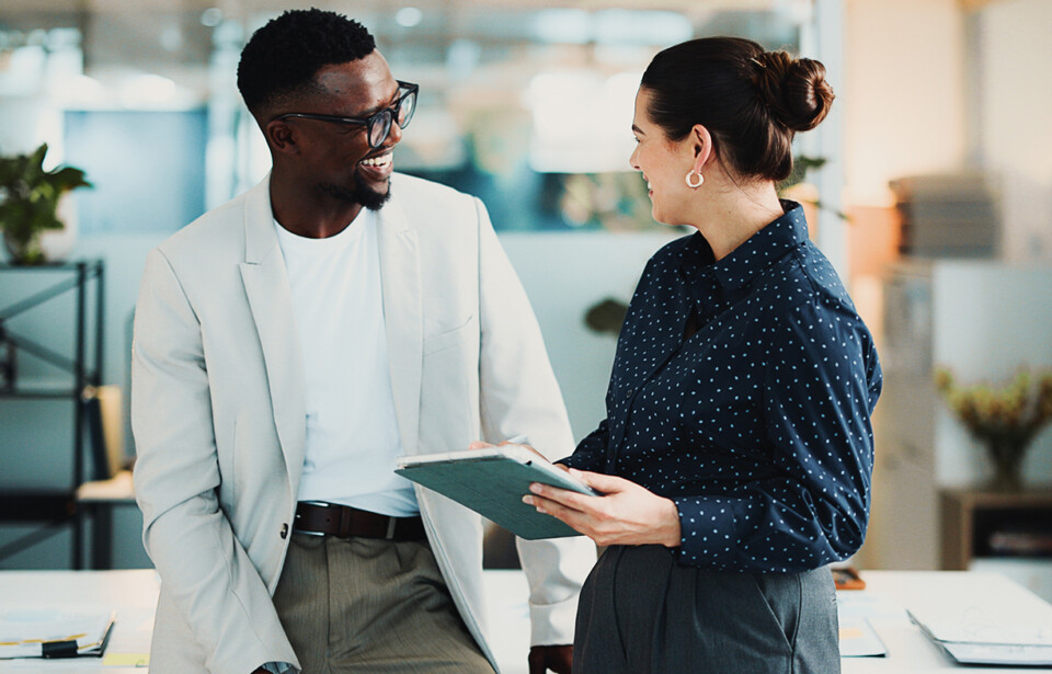 Two business professionals discussing advertising plans in an office.
